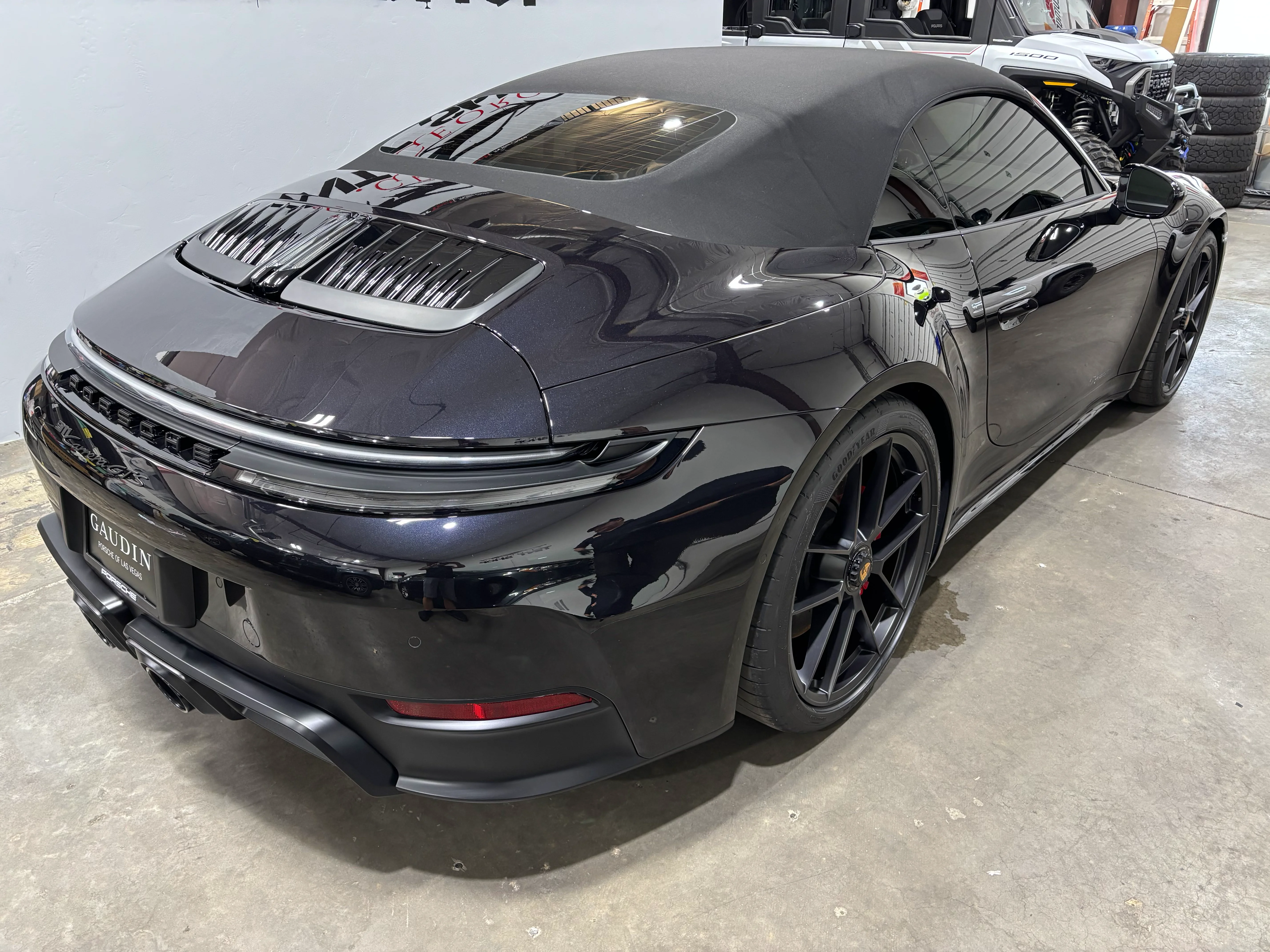 Dark grey Porsche 911 Carrera GTS convertible sedan with professionally installed window tint, parked in a St. George tint shop.