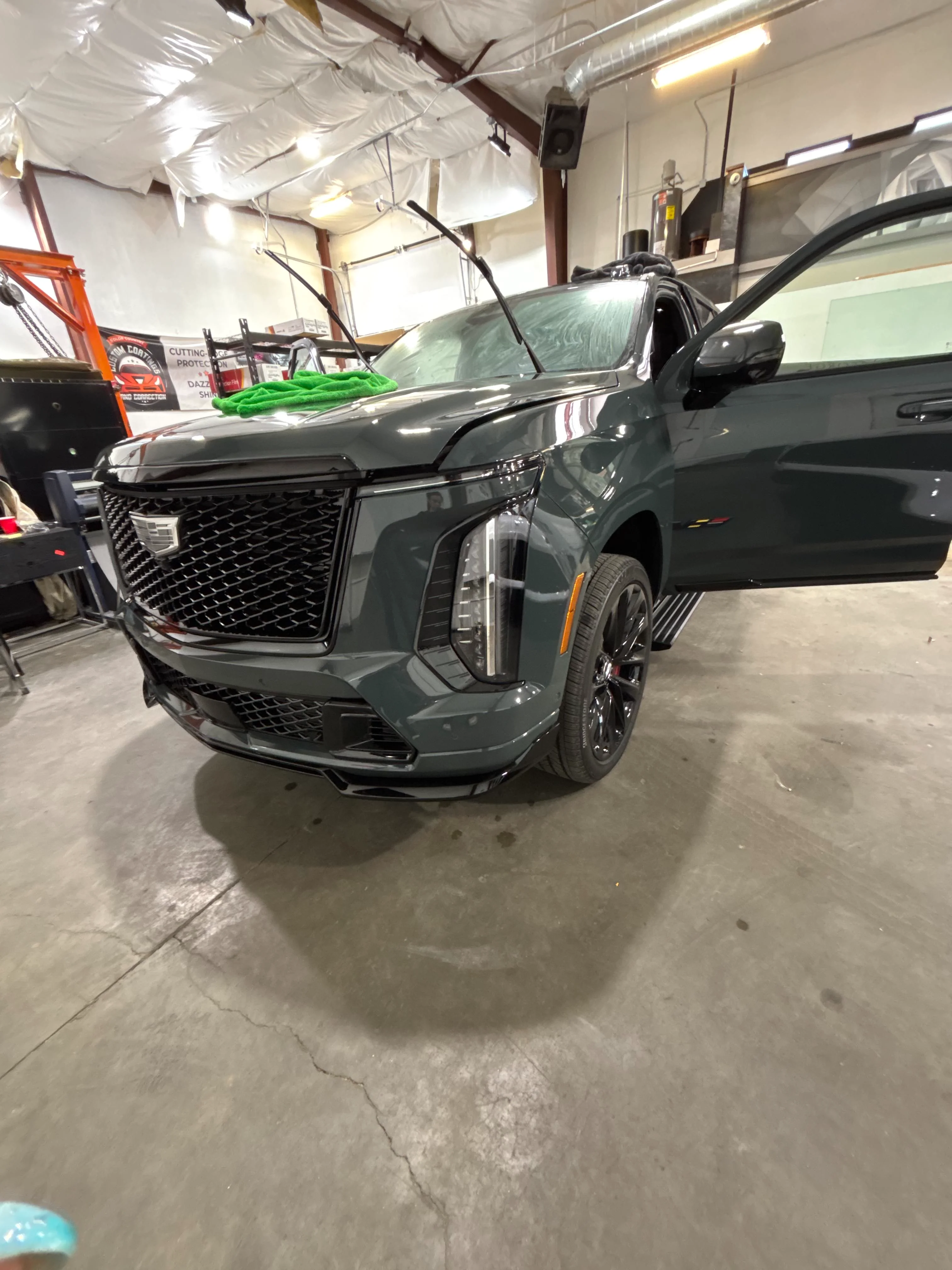 Cadillac Escalade in a professional tint shop in St. George, Utah, with ceramic window tint being applied.