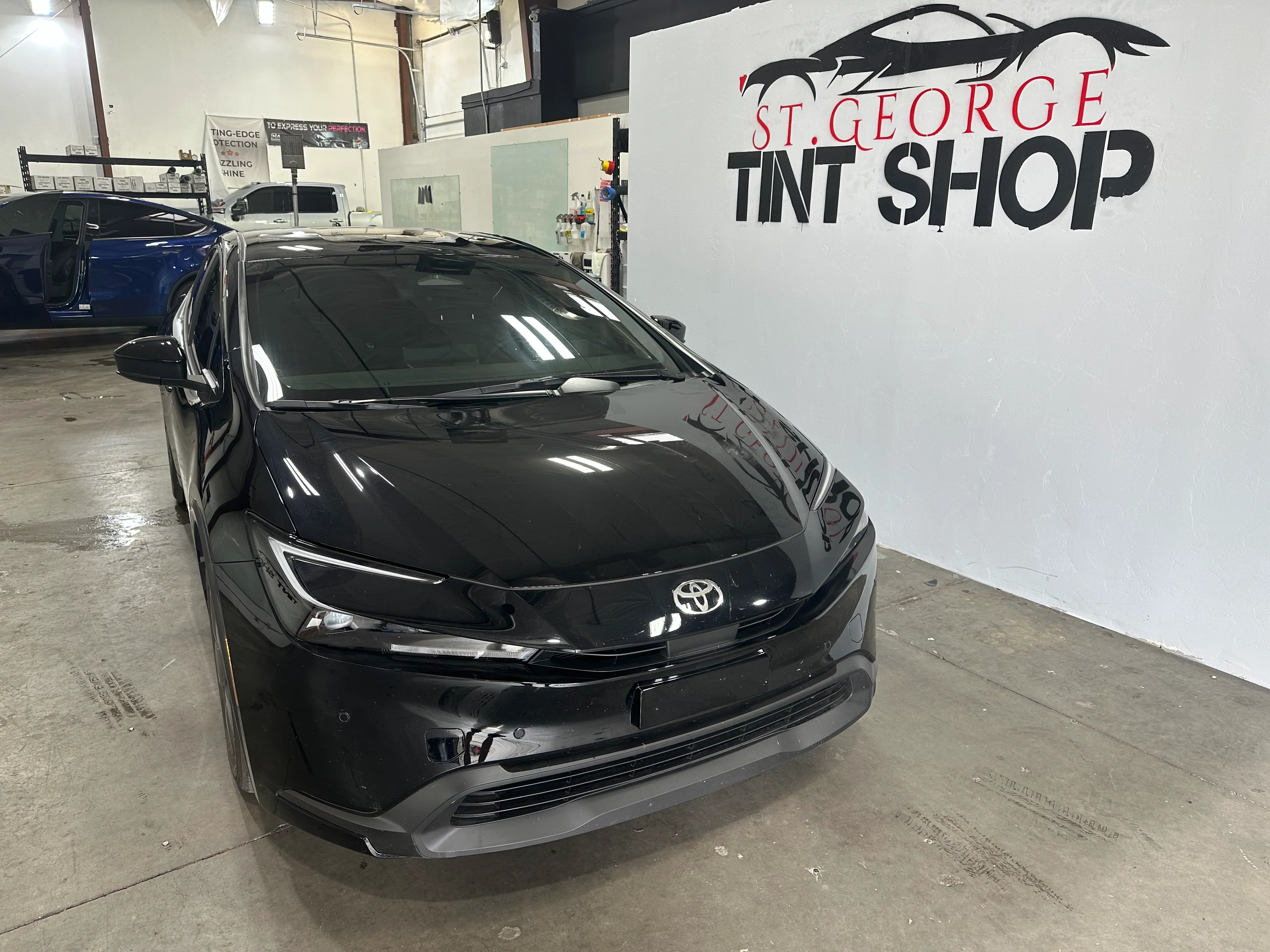A sleek black Toyota sedan showcases expertly installed window tint at a professional shop in St. George, Southern Utah.