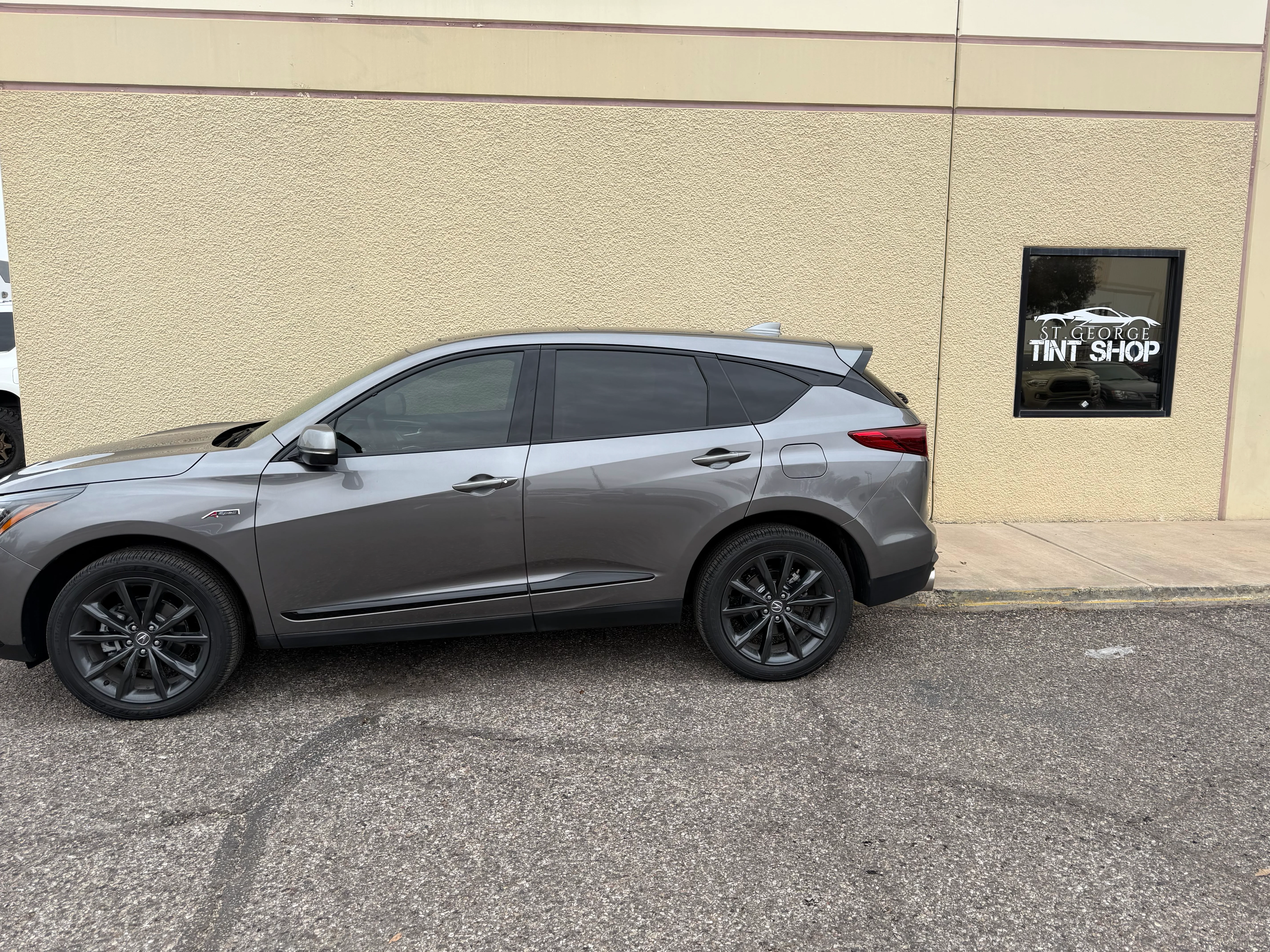 Gray Acura RDX SUV with dark ceramic window tint parked outside a tint shop in St. George, Southern Utah.