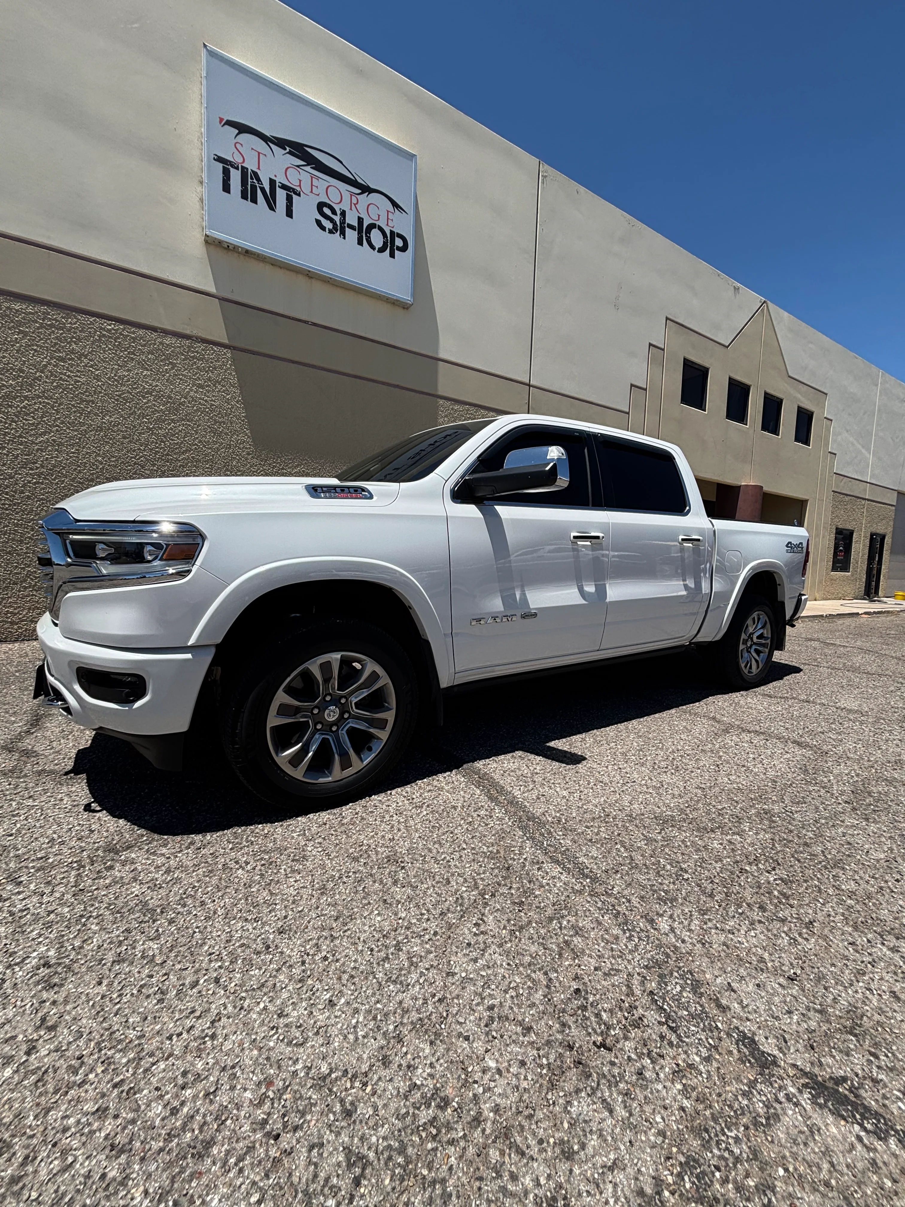 White Ram 1500 truck with professional ceramic window tint parked outside St. George Tint Shop in Southern Utah.
