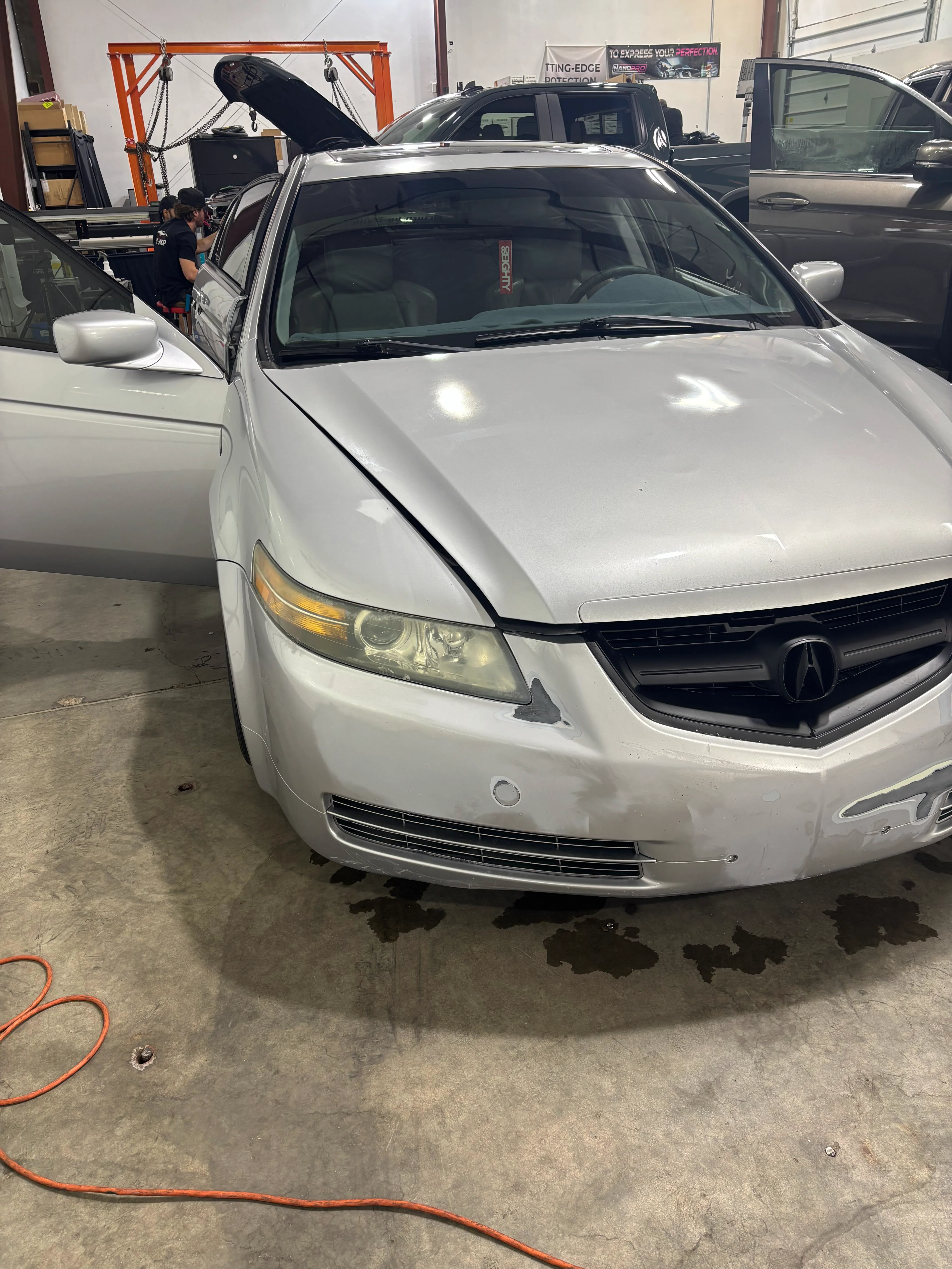 Professional team installing ceramic window tint on a silver Acura sedan in St. George, Utah. Enhances privacy and reduces heat.