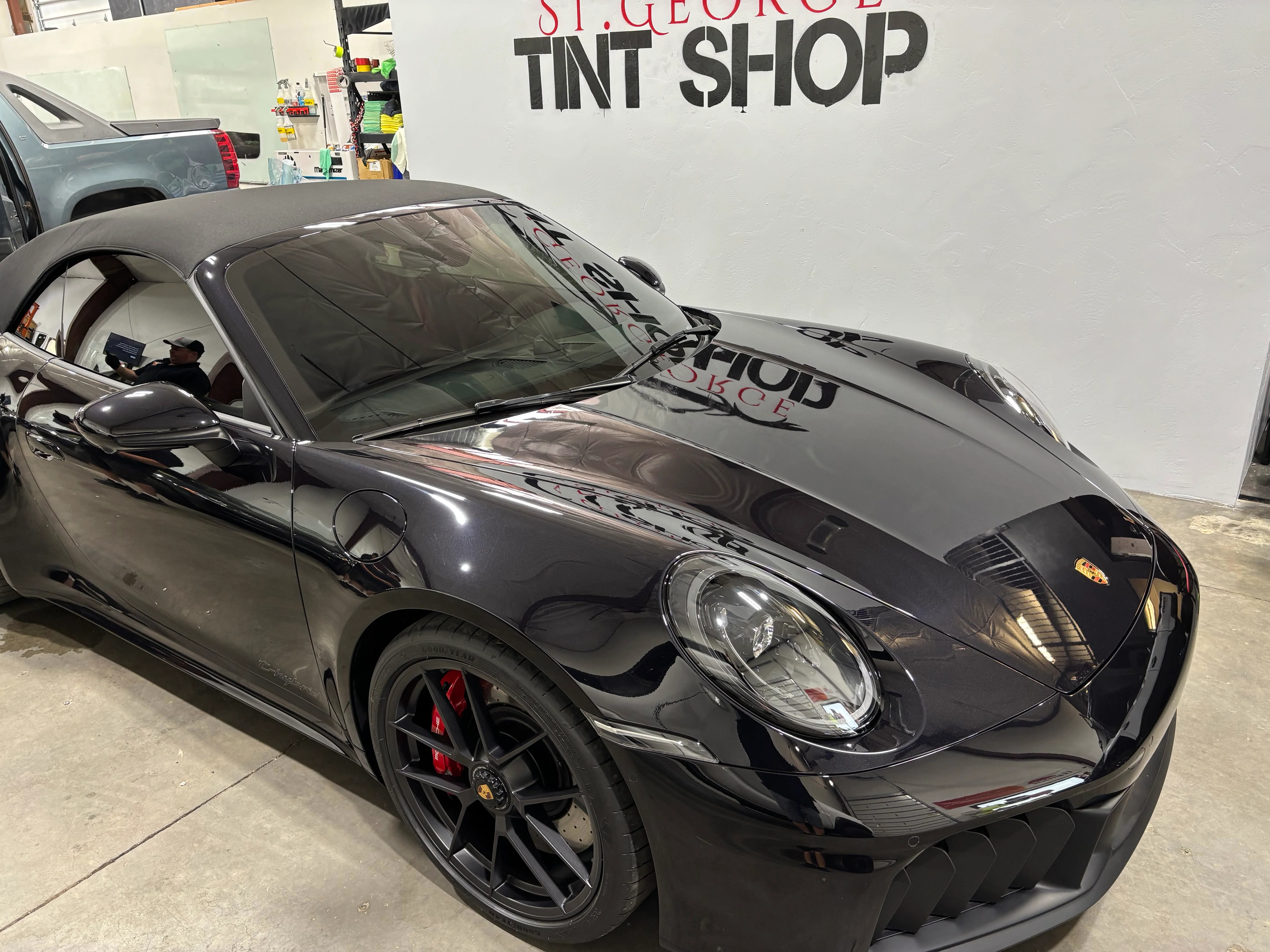 Sleek black Porsche 911 convertible receiving professional ceramic window tinting at a St. George tint shop. High-quality vehicle service in Southern Utah.