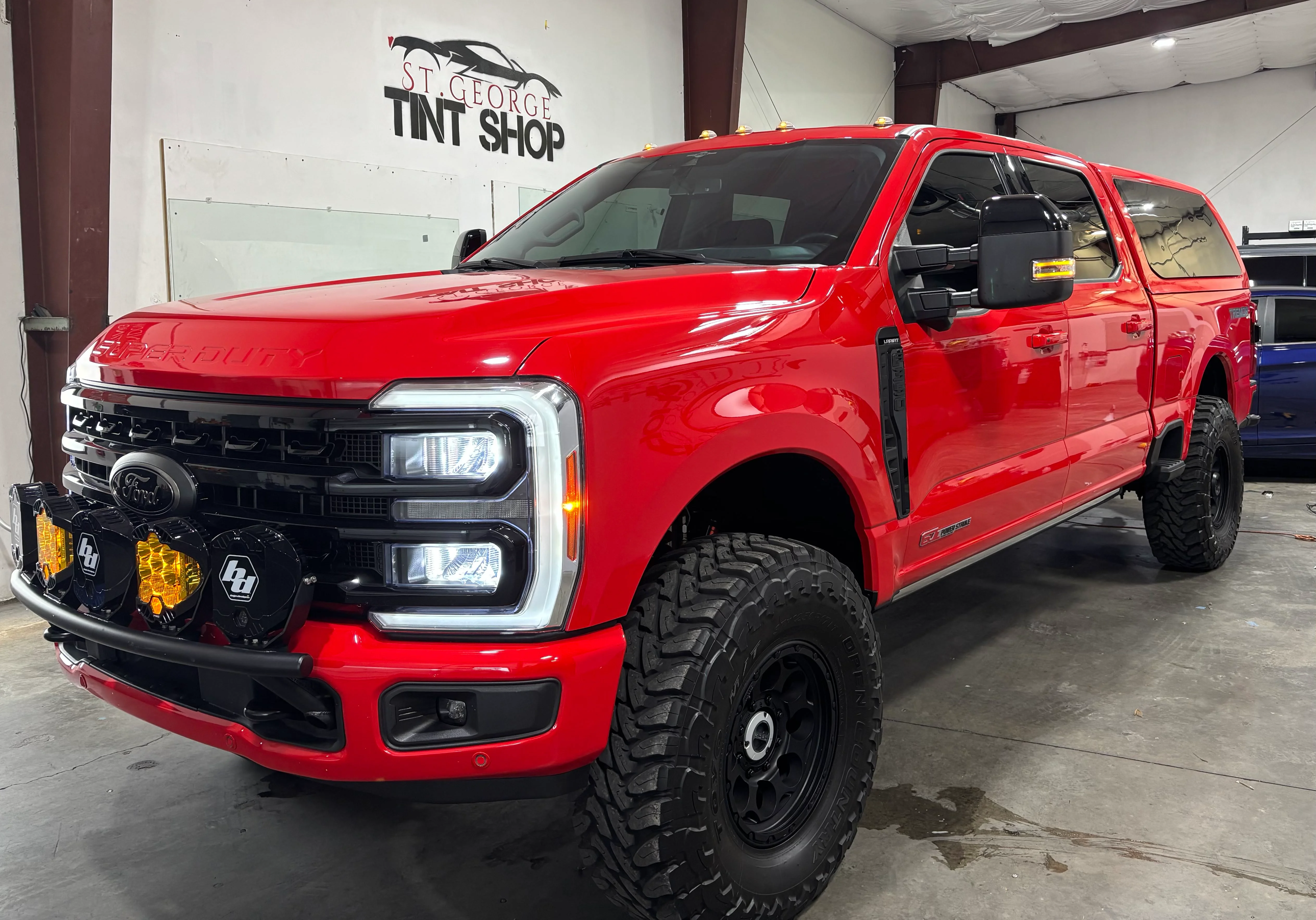 Bright red Ford F-350 Super Duty with dark ceramic window tint professionally installed at St. George Tint Shop in Southern Utah.