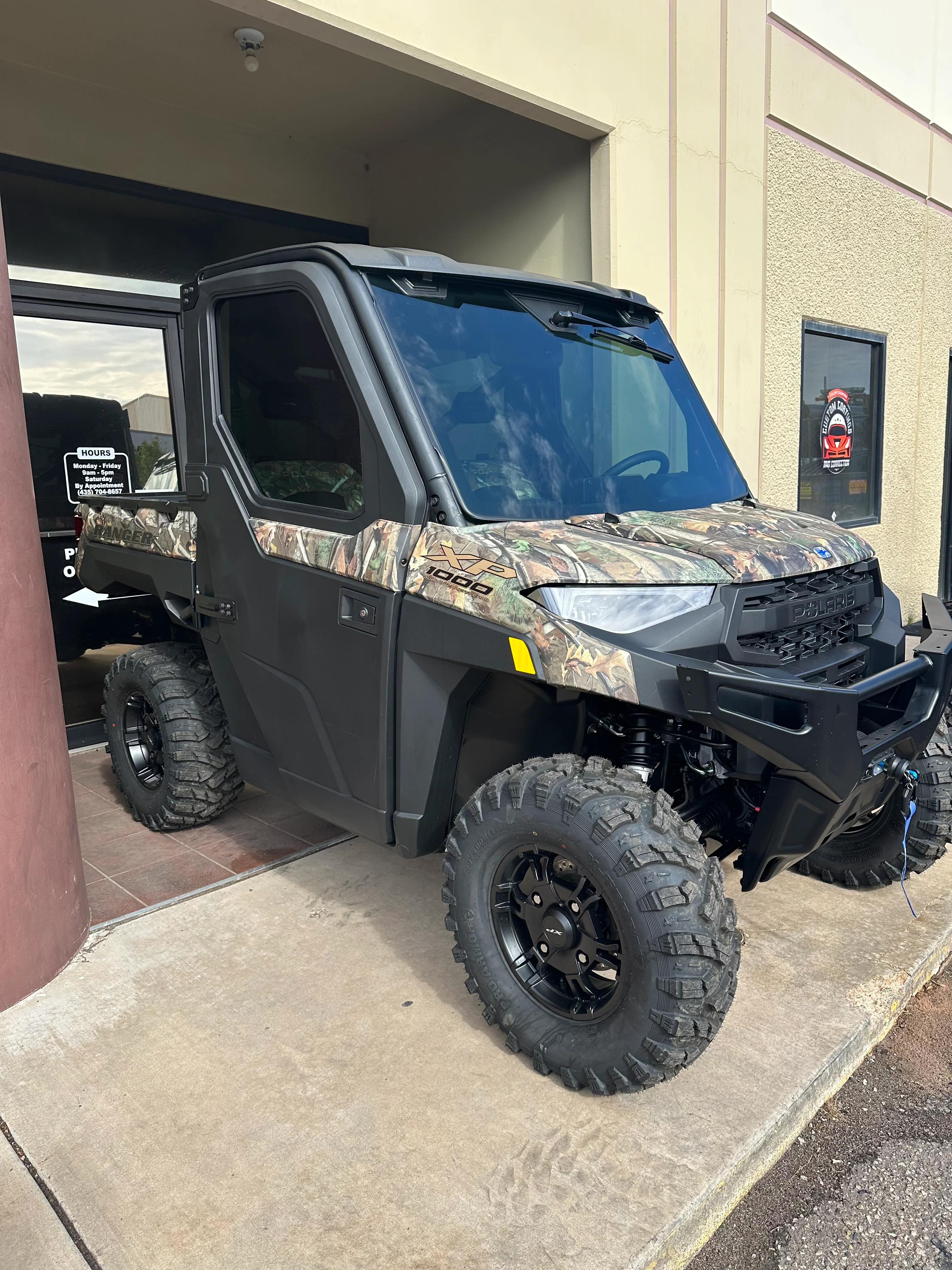 Camo Polaris Ranger XP 1000 UTV with professionally installed window tint, parked outside a tint shop in St. George, Utah.