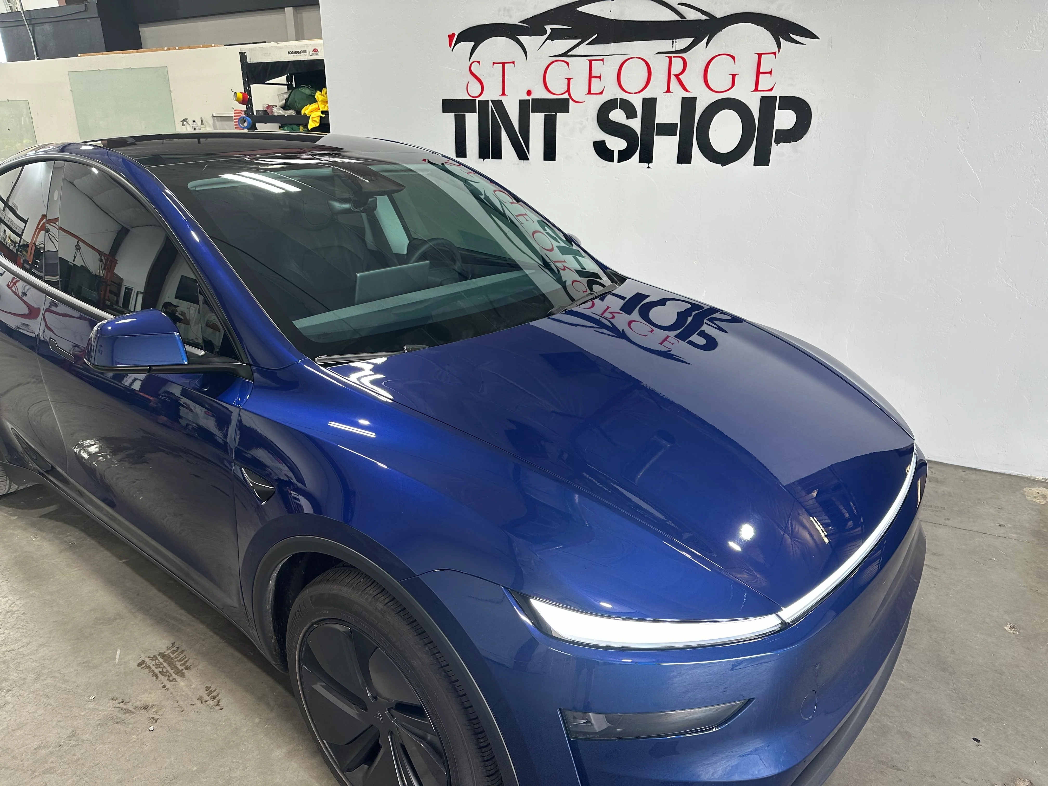 Blue Tesla Model Y with professional ceramic window tint and paint protection film installed at St. George Tint Shop in Southern Utah.