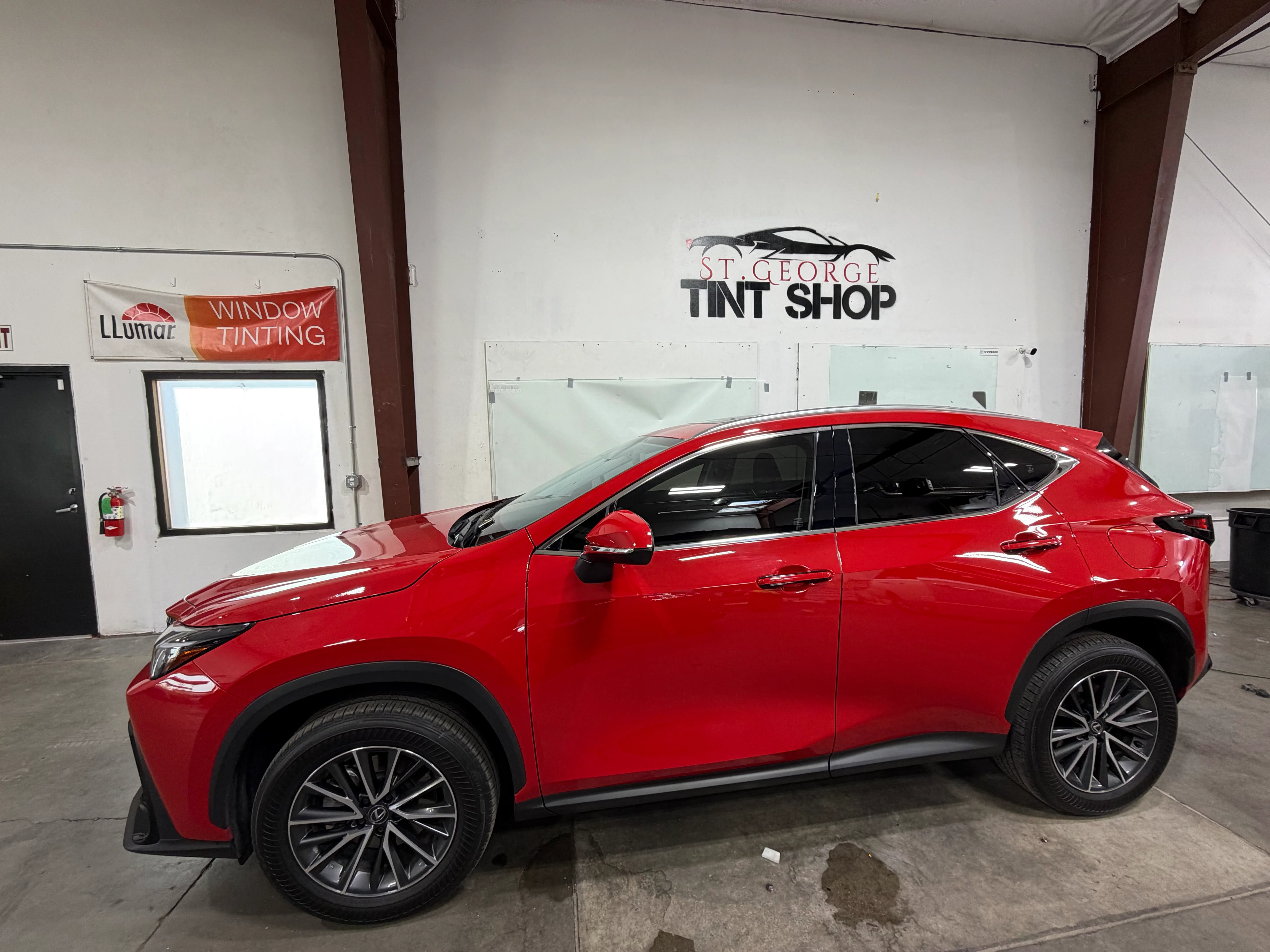 Bright red Lexus NX SUV with dark ceramic window tint professionally installed at St. George Tint Shop in Southern Utah.